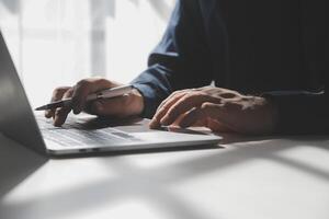 bijgesneden beeld van een jong Mens werken Aan zijn laptop in een koffie winkel, achterzijde visie van bedrijf Mens handen bezig gebruik makend van laptop Bij kantoor bureau, jong mannetje leerling typen Aan computer zittend Bij houten tafel foto