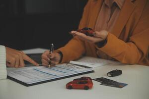 verzekering officieren hand- over- de auto sleutels na de huurder. hebben ondertekend een auto verzekering document of een huren of overeenkomst document buying of verkoop een nieuw of gebruikt auto met een auto foto