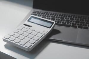 vlak leggen, top visie kantoor tafel bureau. werkruimte met rekenmachine, pen, laptop Aan wit achtergrond.kopie ruimte voor tekst, leeg blanco naar woord.bedrijf financiën, onderwijs technologie.werk van huis. foto