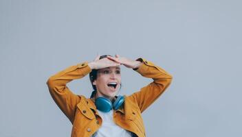 de mooi emotioneel Europese bruin haar vrouw met gezond schoon huid, charmant glimlach, gekleed in gewoontjes licht kleren, luistert en geniet muziek- Aan hoofdtelefoons met tablet Aan een wit achtergrond. foto