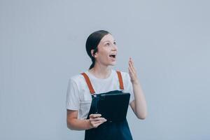 vrolijk mooi Aziatisch vrouw vervelend jeans overall met opgewonden aan het doen winnaar gebaar met armen verheven geïsoleerd Aan wit achtergrond. foto