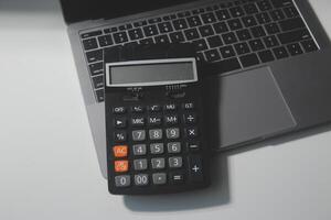 vlak leggen, top visie kantoor tafel bureau. werkruimte met rekenmachine, pen, laptop Aan wit achtergrond.kopie ruimte voor tekst, leeg blanco naar woord.bedrijf financiën, onderwijs technologie.werk van huis. foto