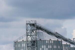 graanschuur lift, zilver silo's Aan agro fabricage fabriek voor verwerken drogen schoonmaak en opslagruimte van agrarisch producten, meel, granen en korrel. groot ijzer vaten van korrel. foto