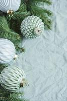 vuren twijgen met kerstversiering op de groene linnen verfrommelde textielachtergrond foto