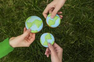 aarde dag concept. handen houden peperkoek in de vorm van de aarde. zorg voor de omgeving. foto