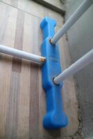 de voet van een Kledinglijn buiten de huis. wit en blauw, gemaakt van hol ijzer en plastic foto