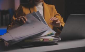 zakenvrouw die rekenmachine gebruikt om wiskunde te financieren op houten bureau in kantoor en zakelijke achtergrond, belasting, boekhouding, statistiek en analytisch onderzoeksconcept foto