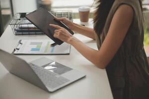 schot van een Aziatisch jong bedrijf vrouw werken Aan laptop in haar werkstation. foto