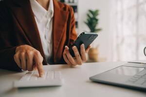 aantrekkelijk glimlachen jong Aziatisch bedrijf vrouw werk Bij huis kantoor, Aziatisch vrouw werken Aan laptop computer Holding tablet. foto