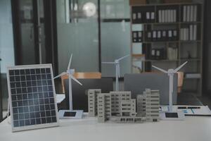 detailopname Bij tablet, ingenieurs richten Bij tablet met hun handen. naar gezamenlijk ontwerp de gebruik van hernieuwbaar energie met wind en zonne- energie. concept van gebruik makend van hernieuwbaar energie. foto