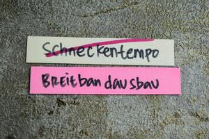 concept van aan het leren taal - Duitse. schneckentempo breitbandausbau het middelen breedband uitbreiding Bij een slakken tempo geschreven Aan kleverig notities. Duitse taal geïsoleerd Aan houten tafel. foto