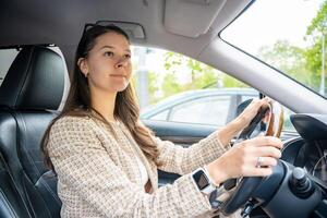 kant portret van jong Kaukasisch vrouw het rijden auto in de stad foto