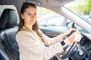 kant portret van jong Kaukasisch vrouw het rijden auto in de stad foto