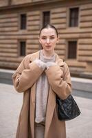 portret van jong mooi vrouw vervelend jas wandelen in de stad centrum van Praag, Europa. hoog kwaliteit foto