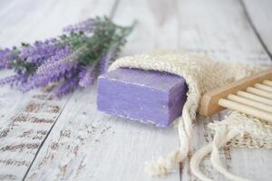 eigengemaakt natuurlijk zeep bar en lavendel bloem Aan tafel foto