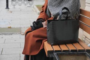 vrouw links haar handtas Aan een bank in een park. foto