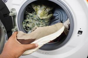 zetten vuil schoen in een het wassen machine. foto