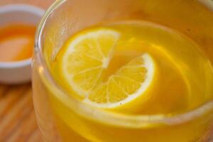 top visie van citroen thee gieten in een kop foto