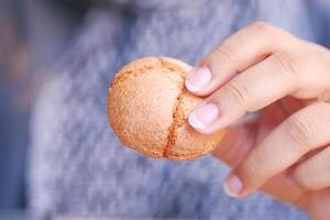 jong vrouw Holding een zoet koekje foto