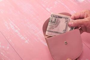 senior Dames hand- besparing contant geld in portemonnee. foto