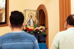 onbekend mensen bidden voorkant van de standbeeld van onze dame van suyapa in de san isidro kathedraal in la ceiba, Honduras. foto