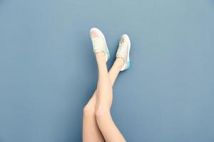 benen van mooie vrouw in stijlvolle schoenen op kleur achtergrond foto