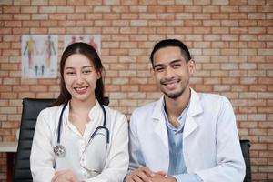 team van gezondheidspartners, portret van twee jonge artsen van Aziatische etniciteit in witte overhemden met stethoscoop, glimlachend en kijkend naar camera in kliniek, personen met expertise in professionele behandeling.
