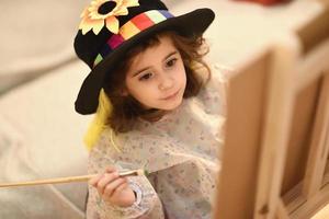 klein meisje dat thuis een foto aan het schilderen is