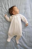 pasgeboren babymeisje slaapt op blauwe lakens foto