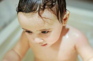 meisje van zes maanden oud in bad foto
