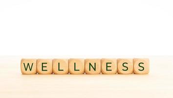 wellness woord in houten blokken op tafel. witte achtergrond. kopieer ruimte