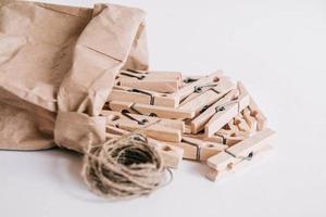 houten wasknijpers in papieren zak met touw op witte achtergrond