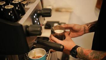 barista doet latte art cappuccino koffie te maken foto