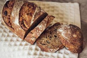 bruin vers brood met zaden wordt in stukjes gesneden op oude houten ondergrond
