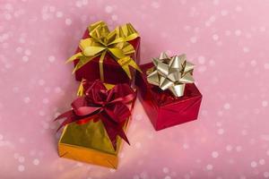 nieuwjaar kerst samenstelling. geschenken op een roze achtergrond met bokehlichten. platte bovenaanzicht kopieerruimte