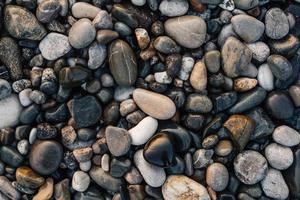 grindpatroon van natte gekleurde stenen. abstracte natuur kiezelstenen achtergrond. stenen achtergrond. zee kiezels strand. bovenaanzicht