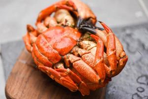 verse krab op een houten bord voor het maken van gekookt voedsel - zeevruchten, schaaldieren, gestoomde rode krab of gekookte steenkrab foto