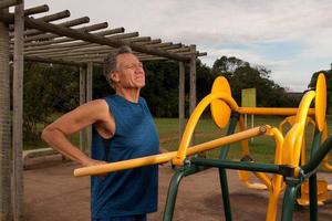 senior volwassen man aan het trainen in een openluchtfitnesspark in parque das garcas, brasilia foto