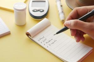 vinkje op een selectievakje op een papier met glucosemeter op tafel foto