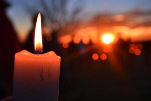 brandend kaars in een begraafplaats Bij zonsondergang foto