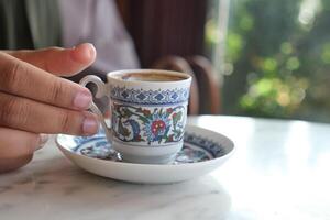 vrouw drinken Turks koffie Bij cafe foto