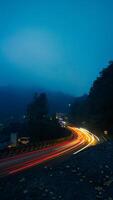 kleurrijk nacht licht trails Aan weg met Woud achtergrond in puncak bogor Indonesië foto