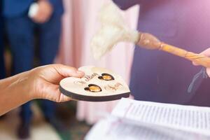 de priester heiligt de bruiloft ringen van de pasgetrouwden in de kerk foto