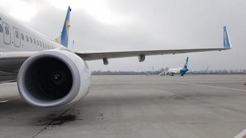 Oekraïne, Borispol - 27 maart 2020. Motorturbine en vleugel van een groot passagiersvliegtuig in afwachting van vertrek op de luchthaven tegen de achtergrond van de luchthaven. de wereld rondreizen. foto