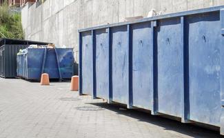 metalen duurzame blauwe industriële vuilnisbak voor buitenafval op de bouwplaats. grote afvalmand voor huishoudelijk of industrieel afval. een hoop afval. foto