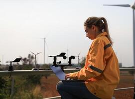 vrouw ingenieur met meting instrument wind snelheid werken Bij wind turbine foto