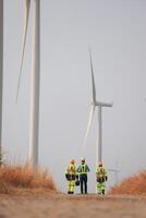 specialist wind turbine team van ingenieurs bespreken groen energie productie in wind turbines boerderij of windmolens veld. team van ingenieur energie planning werkzaamheid in windmolens industrieel Oppervlakte foto