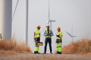 specialist wind turbine team van ingenieurs bespreken groen energie productie in wind turbines boerderij of windmolens veld. team van ingenieur energie planning werkzaamheid in windmolens industrieel Oppervlakte foto