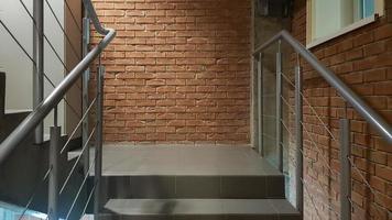 rode bakstenen gebouw met een moderne trap in een loft-stijl met metalen reling. trappen sieren het gebouw. modern trappenhuis. stalen reling. trap in perspectief. foto