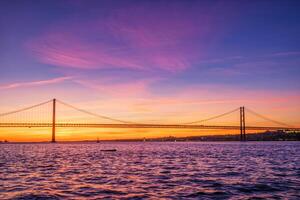 visie van 25 de abril brug over- tagus rivier- Aan zonsondergang. Lissabon, Portugal foto